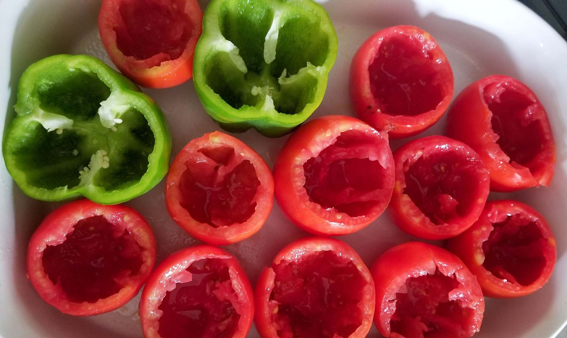 pepper and tomato shells in a baking dish