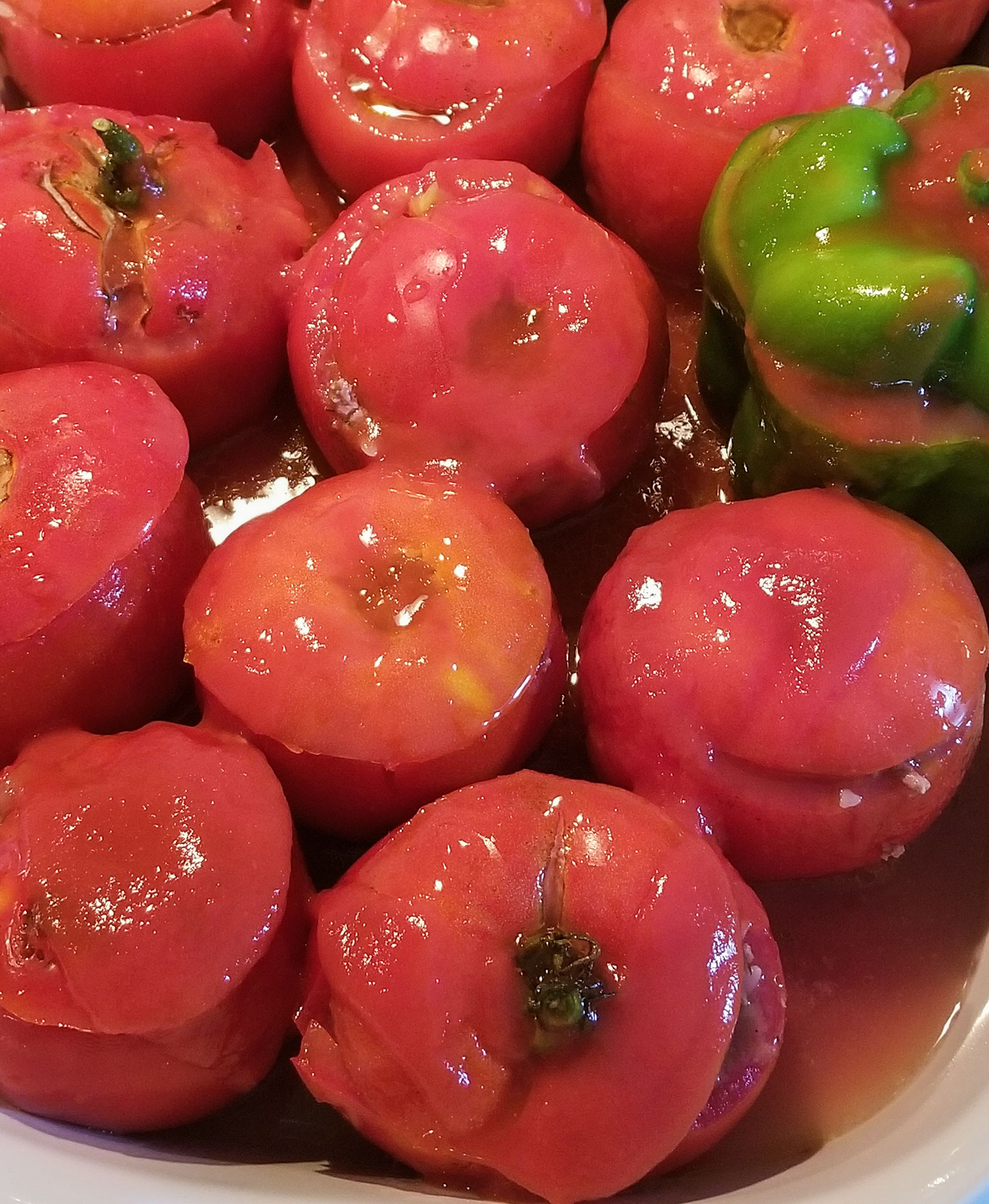 peppers and tomatoes stuffed with a meat and rice mixture and topped with tomato sauce