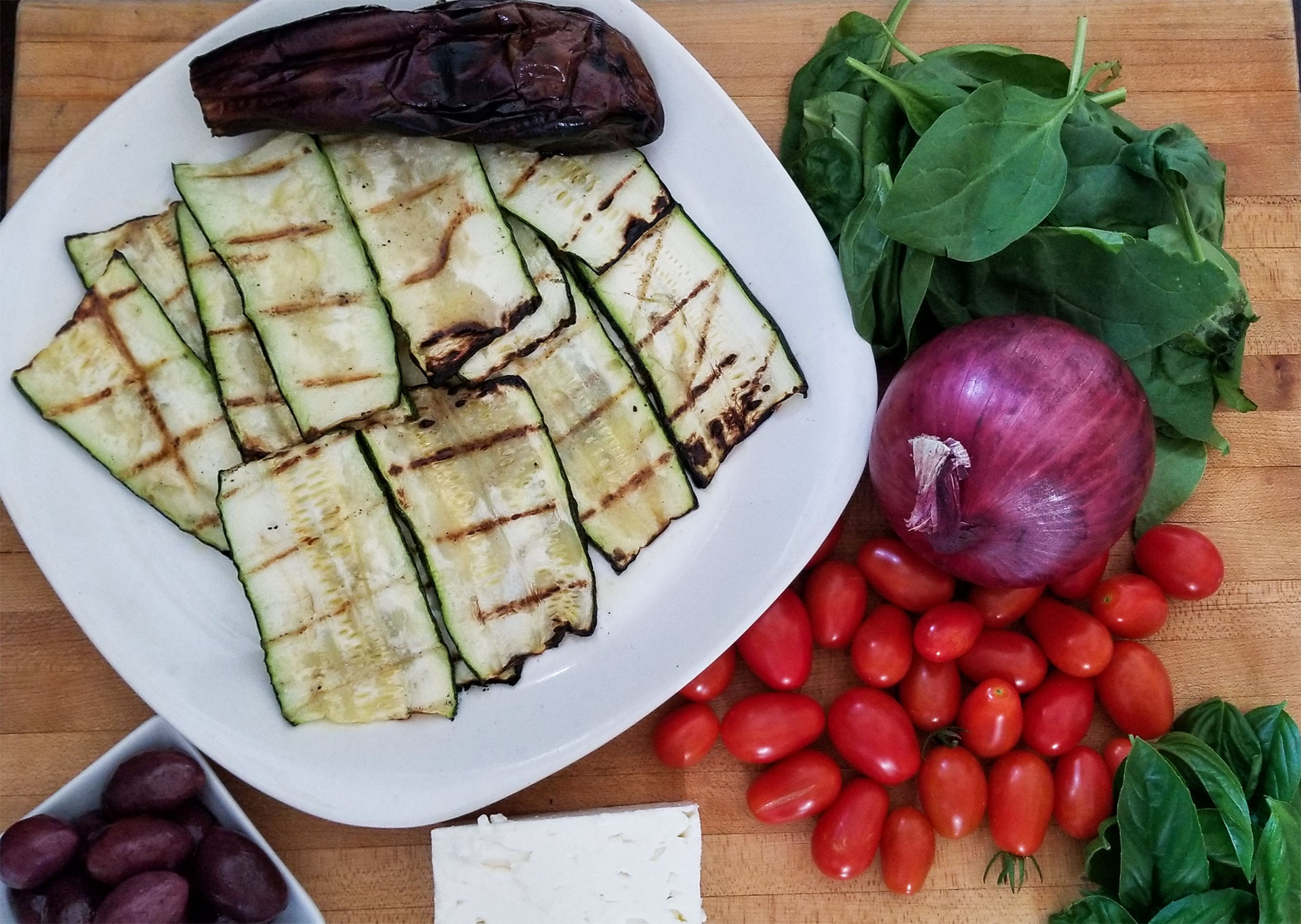 Grecian pasta ingredients including grilled eggplant and zucchini and other fresh vegetables