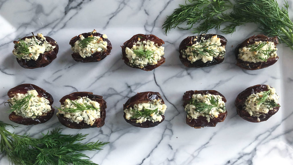 Feta Stuffed Dates arranged on a plate with fresh dill