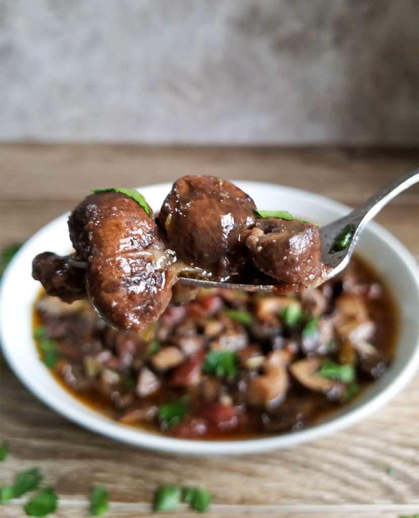 Greek mushroom stew in a bowl and on a fork