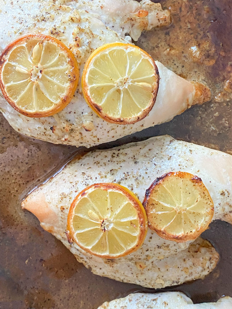 Cooked lemon chicken breasts on a sheet pan