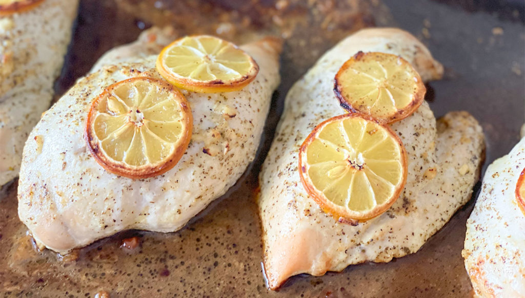 Cooked lemon chicken breasts on a sheet pan